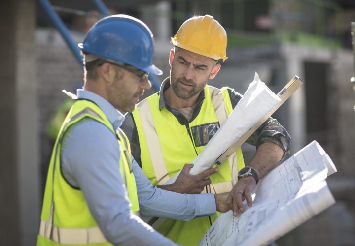 Project manager and construction worker looking at plans
